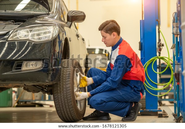 Car mechanic changing tire\
in professional car repair,Car Maintenance in the Professional\
Service.