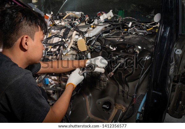 The car mechanic is checking the\
car after the accident ,car electrician repairs\
car