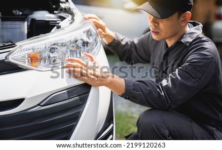 Car mechanic checking headlights adjusting the headlights on the car by mechanics