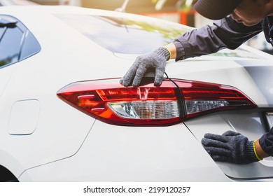 Car mechanic checking tail lights Adjust the brake lights by a mechanic - Powered by Shutterstock