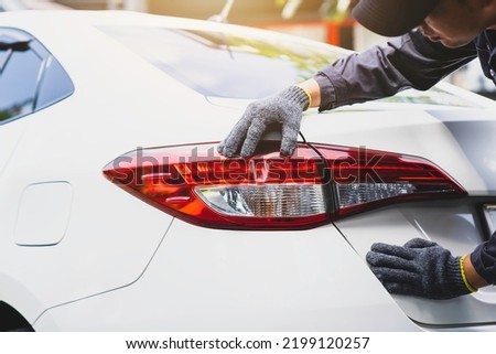 Car mechanic checking tail lights Adjust the brake lights by a mechanic
