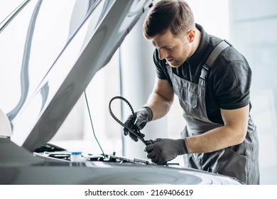 Car mechanic checking timing belt - Powered by Shutterstock