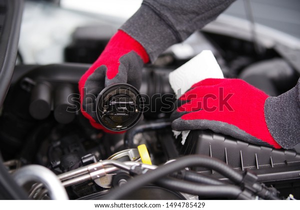 \
Car mechanic\
checks the oil level of a\
car