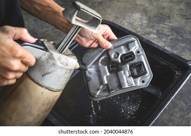 Car Mechanic Cleaning Automatic Transmission Filter On Oil Drain Pan.