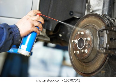 Car Mechanic Cleaning Car Wheel Brake Disk From Rust Corrosion At Automobile Repair Service Station