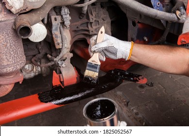 A Car Mechanic Cleans And Maintains The Engine Chassis Of An Old Car Against Corrosion And Protects It With A Preparation