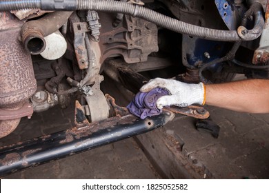 A Car Mechanic Cleans And Maintains The Engine Chassis Of An Old Car Against Corrosion And Protects It With A Preparation