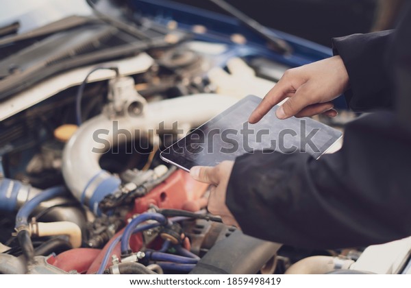 car mechanic doing auto diagnostic using computer,
searching for check engine