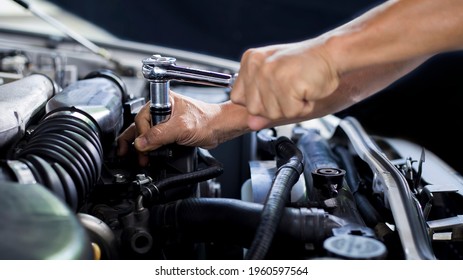 A car mechanic is doing a car repair in a repair shop.