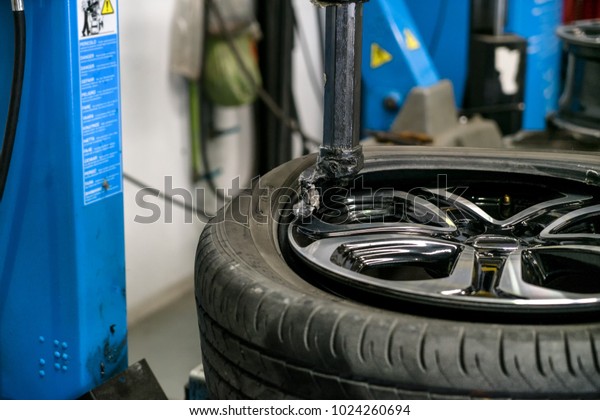 Car mechanic during\
suspension adjustment and automobile tire alignment work at repair\
service station\
