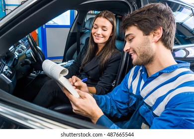 Car mechanic with female customer going through maintenance checklist in automobile shop - Powered by Shutterstock