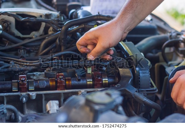 car mechanic fixing car engine, auto mechanic is\
repairing car engine