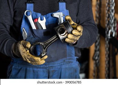 Car mechanic in garage with old car engine piston. Concept - Powered by Shutterstock