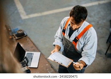 Car mechanic going through paperwork while working in a repair shop. - Powered by Shutterstock