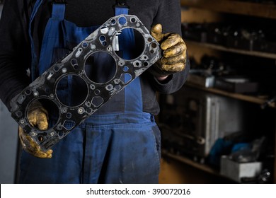 Car mechanic hands in garage with old engine gasket. Concept