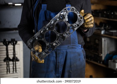 Car Mechanic Hands In Garage With Old Engine Gasket. Concept