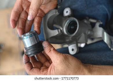 Car Mechanic Hands Rebuilding Car Piston Brake Calipers.