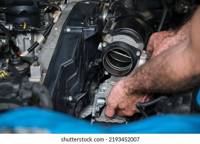 Car Mechanic Hands Replacing Engine Throttle Body. Mechanics Workshop.