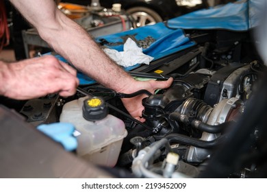 Car Mechanic Hands Replacing Engine Throttle Body. Mechanics Workshop.