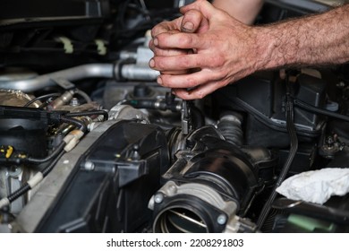 Car Mechanic Hands Replacing Engine Throttle Body. Mechanics Workshop.