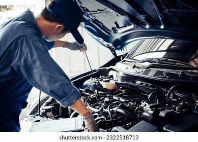 Car mechanic holding checking gear oil to maintenance vehicle by customer claim order in auto repair shop garage. Engine repair service. People occupation and business job. Automobile technician - Powered by Shutterstock