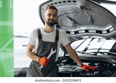 Car mechanic holding wrench for car repair - Powered by Shutterstock