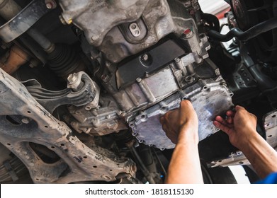 The Car Mechanic Installing An Automatic Transmission Oil Pan.