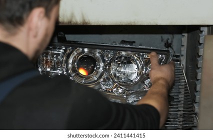 The car mechanic installs the lens in the headlight housing. The concept of a car service. Installation of BI-LED lenses in the headlight. BI-LED lens. Restoration of optics.