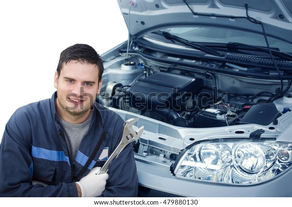 Car mechanic.\
Isolated mechanic holding wrench and standing next to the car with\
an opened hood. Car\
service.