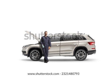 Car mechanic leaning on a SUV with an open hood isolated on white background 

