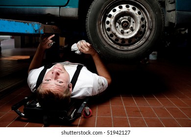 Car Mechanic Lying Under The Car