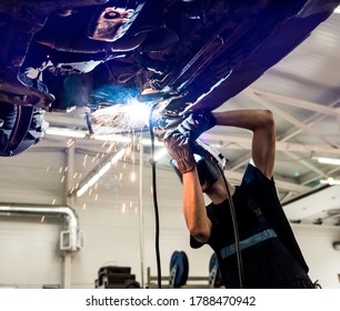 Car mechanic with protective mask welding car. Service station - Powered by Shutterstock