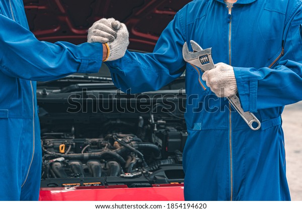 Car Mechanic Ready For Work. Auto
Mechanic with Large Wrench in Hands. Ideas How to Fix the
Problem.Male mechanics at the garage fixing a car.Closed up focus
.