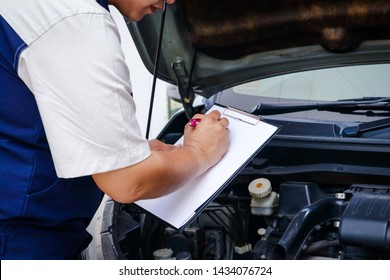 The Car Mechanic Is Recording The Checklist Of The Car's Bad Condition.