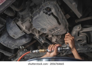 Car Mechanic Removing the Automatic Transmission Oil Pan.