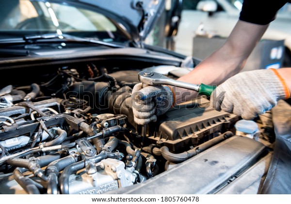 Car\
mechanic repair engine at service station. Car\
repair