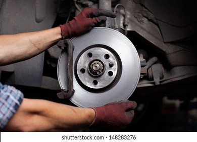 Car Mechanic Repairing Brakes On Car