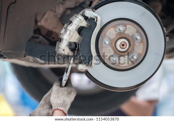 Car mechanic Repairing\
brakes on car