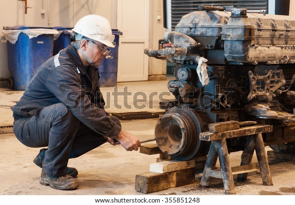 The car mechanic\
repairs the truck engine