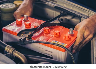 A car mechanic replaces a battery