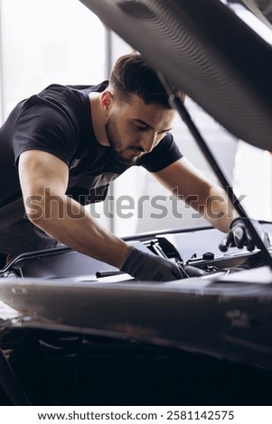 Car mechanic at car service checking up the car
