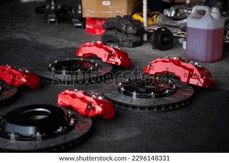 Car mechanic or serviceman disassembly and checking a disc brake and asbestos brake pads for fix and repair problem at car garage or repair shop