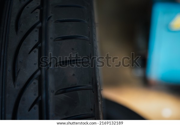 Car mechanic or serviceman wheel alignment\
and tire balance checking car wheel for fix and repair suspension\
problem at car garage or repair\
shop