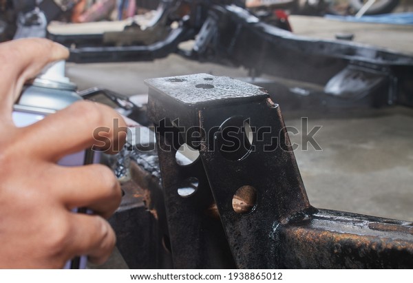 Car Mechanic Spray Paint Car Chassis for Rust\
Protection in Garage