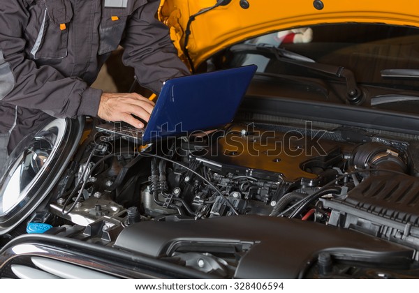 Car\
mechanic with a tablet making a diagnosis\
engine