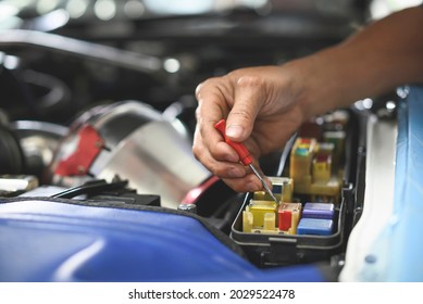 Car mechanic testing fuses and relays in the  fuse box ,Car Engine Service.