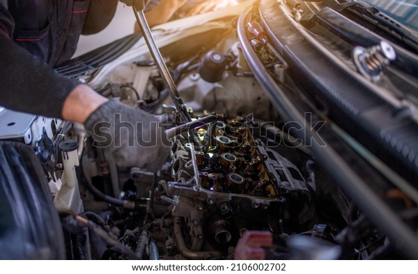 Car mechanic\
under repairing car  open hood checking electric line car system\
and clean in car garage\
service.