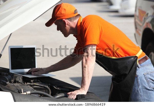 car mechanic use notebook\
computers to check engine and service maintenance of industrial to\
engine repair, for transport automobile automotive\
