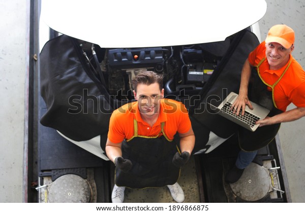 car mechanic use\
notebook computers to check engine and service maintenance of\
industrial to engine repair, for transport automobile automotive ,\
top view image 
