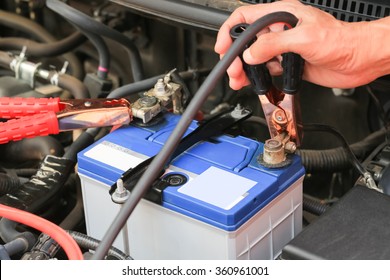 Car Mechanic Uses Battery Jumper Cables Charge A Dead Battery.